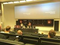 View from the seat in the lecture hall towards the speaker and slides at IT University Copenhagen.